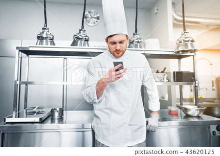 chef cook with smartphone at restaurant kitchen chef cook with smartphone at restaurant kitchen 43620125
