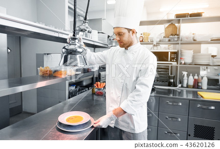 happy male chef cooking food at restaurant kitchen happy male chef cooking food at restaurant kitchen 43620126