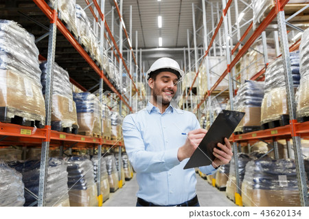 businessman in helmet with clipboard at warehouse businessman in helmet with clipboard at warehouse 43620134