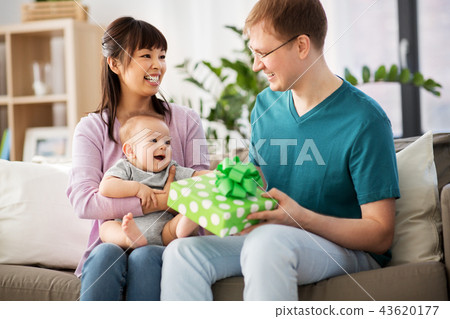 mother with baby giving birthday present to father mother with baby giving birthday present to father 43620177