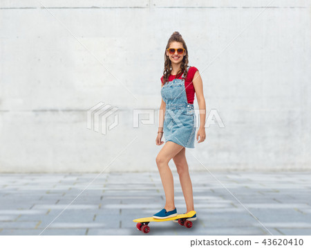 smiling teenage girl with skateboard on street 43620410