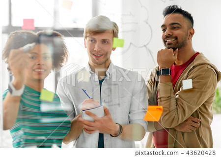 creative team writing on glass board at office 43620428