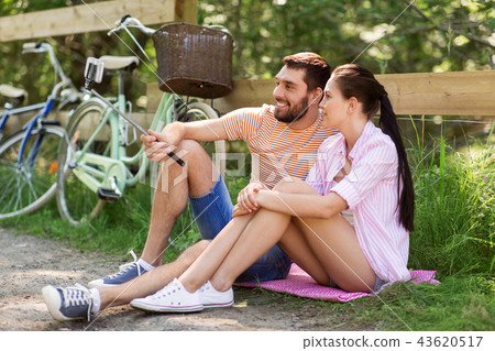 couple with bicycles taking selfie by smartphone 43620517