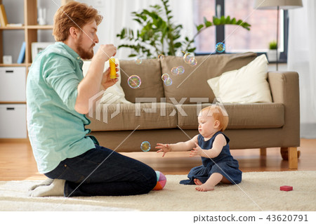 father and baby daughter with soap bubbles at home 43620791