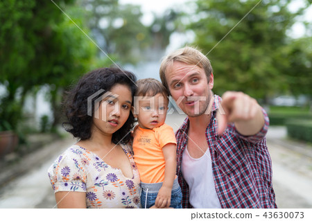 Portrait of happy multi-ethnic family bonding together outdoors 43630073