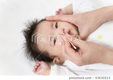 A manual picture explaining how to clean the newborn's nose, a close-up to clean the nose with a cotton swab A manual picture explaining how to clean the newborn's nose, a close-up to clean the nose with a cotton swab 43630523