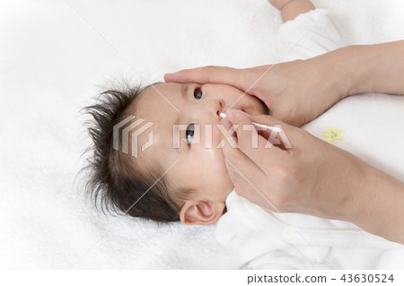 A manual picture explaining how to clean the newborn's nose, a close-up to clean the nose with a cotton swab 43630524