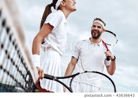 They play like a team. Beautiful young woman and man holding tennis racket and discussing set They play like a team. Beautiful young woman and man holding tennis racket and discussing set 43636643