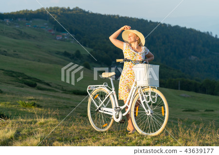 girl with a bicycle on a rural road 43639177