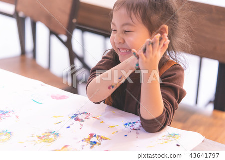 kid laughing while getting messy with art work 43641797