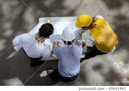 Engineer team discuss project blueprint 43641961