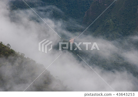 Red water river in the valley behind clouds. 43643253