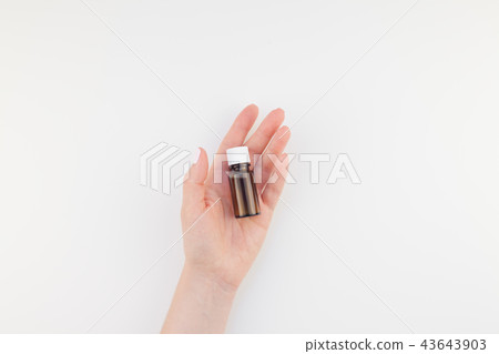 Woman hand with small glass bottle isolated Woman hand with small glass bottle isolated 43643903