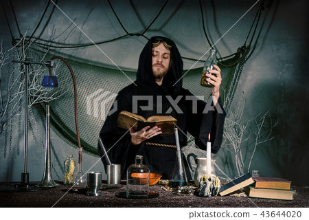 scientist medieval scientist in lab reads a spell. 43644020