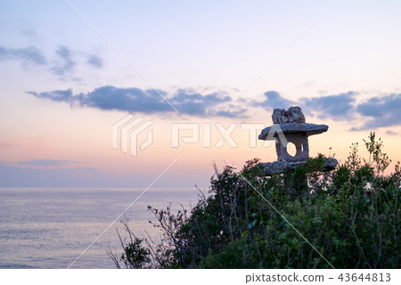 Silhouette of an old stone lantern at sunset 43644813