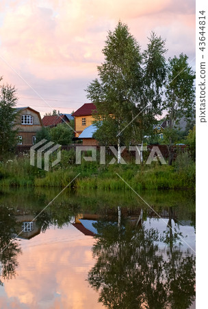 Village houses in a reflection of the lake sunset Village houses in a reflection of the lake sunset 43644814