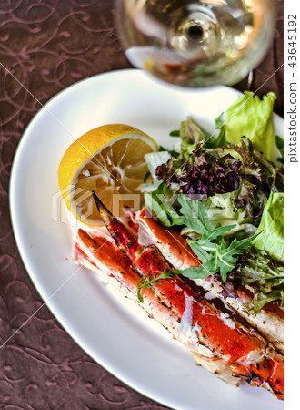Defocus legs or claws of king crab, lemon and wine 43645192