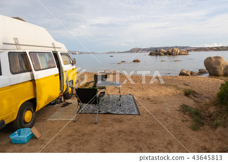 Vintage minivan car on camping spot on beach on Sardinia island, Italy. Vintage minivan car on camping spot on beach on Sardinia island, Italy. 43645813