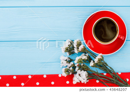 Coffe cup, white statice flowers and dotted towel. 43648207