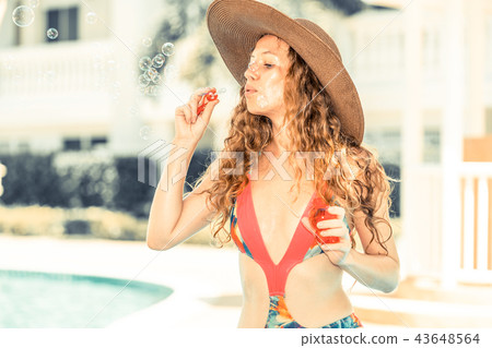 Happy young woman in swimsuit at swimming pool. 43648564