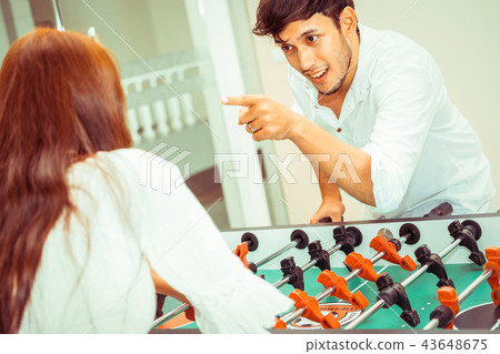 Happy couple playing foosball table. 43648675