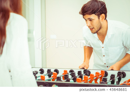 Happy couple playing foosball table. 43648681
