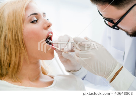 Young dentist examining patient in dental clinic. 43648808