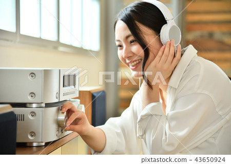 與音頻的少婦觀看的音樂在客廳 43650924