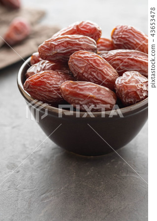 Fresh Medjool Dates in a bowl. Ramadan kareem. Black background. Top view. Copy space. Fresh Medjool Dates in a bowl. Ramadan kareem. Black background. Top view. Copy space. 43653478
