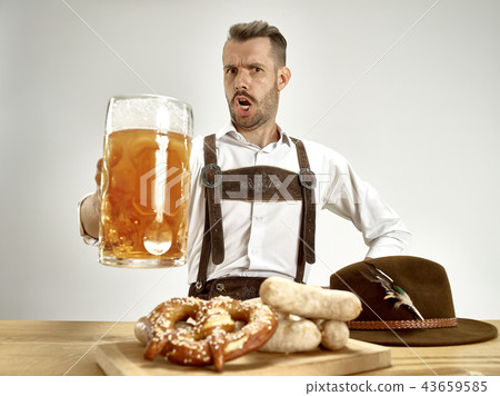 Germany, Bavaria, Upper Bavaria, man with beer dressed in traditional Austrian or Bavarian costume 43659585