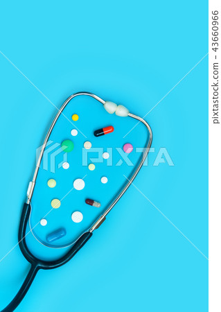 Stethoscope and different pills on blue background 43660966