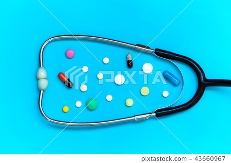 Stethoscope and different pills on blue background 43660967