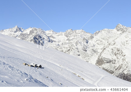 Old pasture huts in scenic winter background 43661404