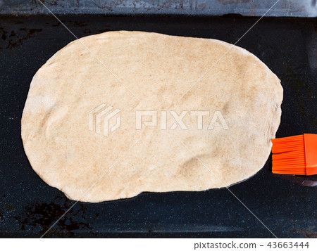 sheet of raw dough on baking tray 43663444
