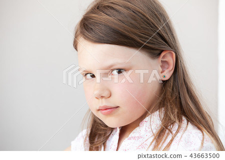 Face portrait of serious blond little girl 43663500