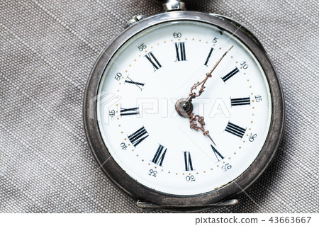 shabby pocket watch on gray textile background shabby pocket watch on gray textile background 43663667