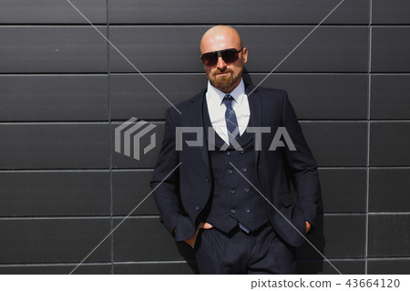 Confident and successful. Handsome young businessman looking away while walking outdoors with office Confident and successful. Handsome young businessman looking away while walking outdoors with office 43664120