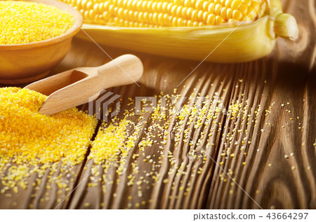 Bowl of corn grits and corncob on kitchen table 43664297