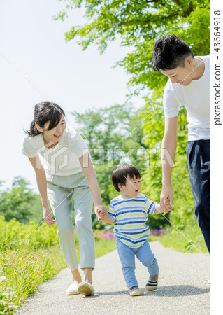 Three-person family playing in a fresh green park 43664918