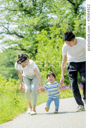 Three-person family playing in a fresh green park 43664922