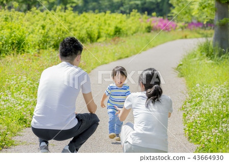 Three-person family playing in a fresh green park 43664930