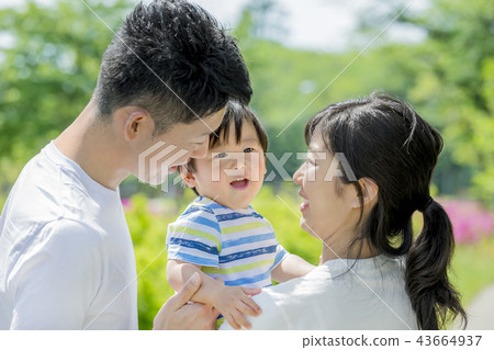 Three-person family playing in a fresh green park 43664937