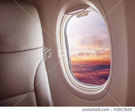 Airplane interior with window view of sunset  43667684