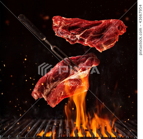 Flying pieces of beef steaks on black Flying pieces of beef steaks on black 43667954