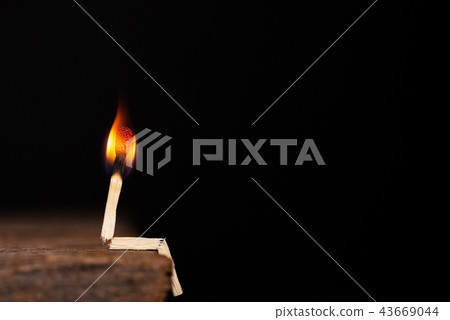 Burning match human sitting on wooden table Burning match human sitting on wooden table 43669044