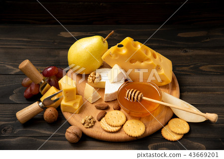Assorted cheeses on a round wooden board 43669201