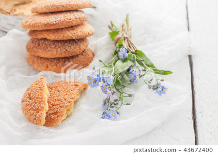 On a white table, sandy round cookies, one broken 43672400