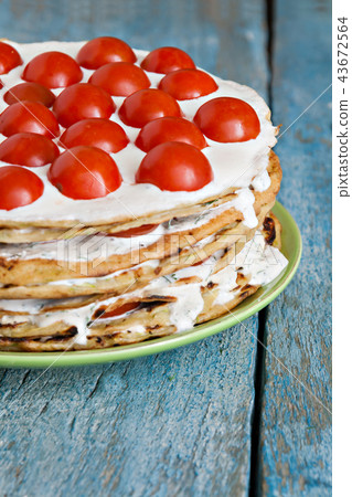 zucchini cake with tomatoes on a blue wooden zucchini cake with tomatoes on a blue wooden 43672564