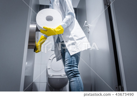 Janitor woman changing paper in public toilet 43673490