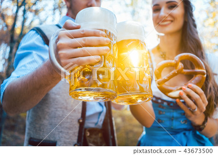 Couple toasting with beer in Bavaria 43673500